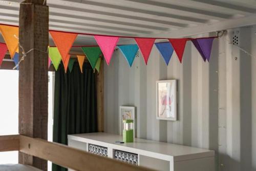 a room with colorful flags hanging from a ceiling at 5 Kestrels Perch, Camp Tapnell in Yarmouth