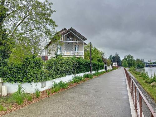 a house on the side of a road next to a river at Maison sur l'eau avec jardin et piscine in Bellerive-sur-Allier