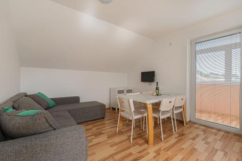 ein Wohnzimmer mit einem Sofa, einem Tisch und Stühlen in der Unterkunft Apartments Lavrič - Happy Rentals in Velike Bloke