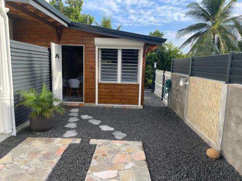 a house with a gravel walkway leading to a door at Le Kokon chic in Sainte-Anne