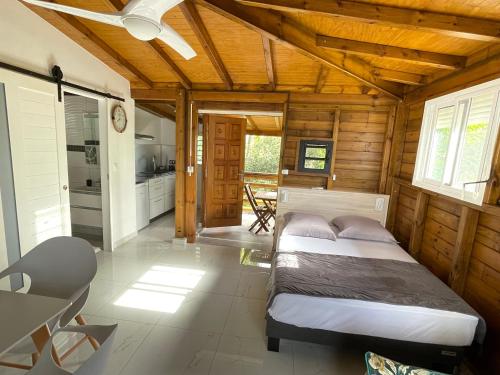 a bedroom with a bed in a wooden cabin at Le Kokon chic in Sainte-Anne