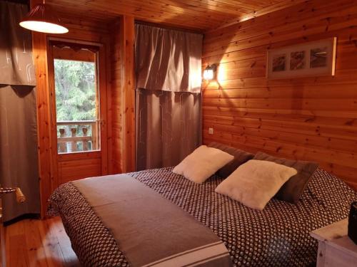 une chambre avec un lit dans une cabane en bois dans l'établissement Chalet bois 45M2, à Bolquère-Pyrénées 2000