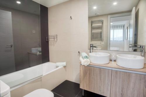 a bathroom with two sinks and a tub and a toilet at Penthouse on the first line in Platja d'Aro