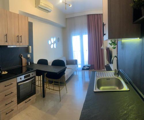 uma cozinha e sala de estar com um lavatório e um sofá em Casa D'oro Α2 em Lárissa