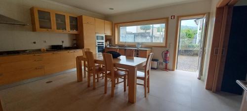 a kitchen with a table and chairs and a kitchen with a window at Vivenda do Parque Arouca in Arouca