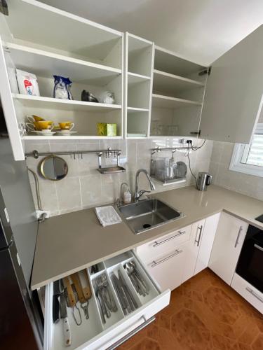 a kitchen with white cabinets and a sink at Bat Yam Garden in Bat Yam