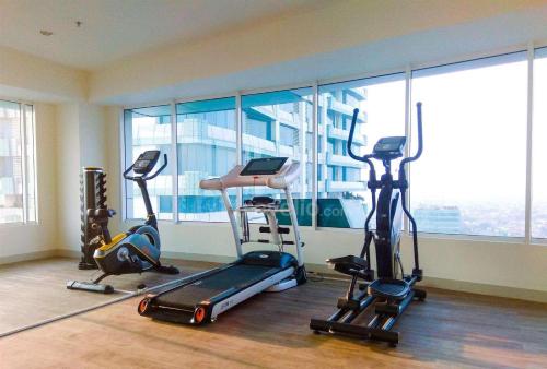 a gym with treadmills and exercise equipment in front of a window at Boboroombyindri in Pulosirih