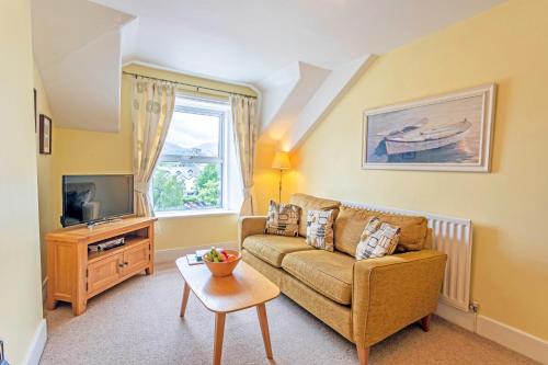 a living room with a couch and a tv at Keswick View in Keswick