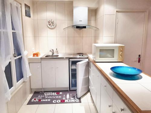 a kitchen with a microwave and a blue bowl on the counter at Maison de 2 chambres avec wifi a Gace in Gacé