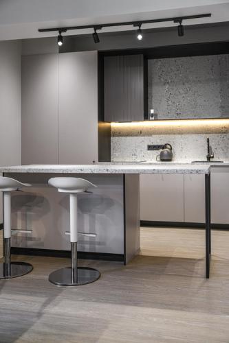 a kitchen with a large marble counter and stools at Apartments in Vilnius in Vilnius