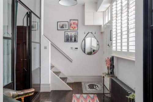 a hallway with white stairs and a mirror at Magic Moments - London Bridge - by Frankie Says in London