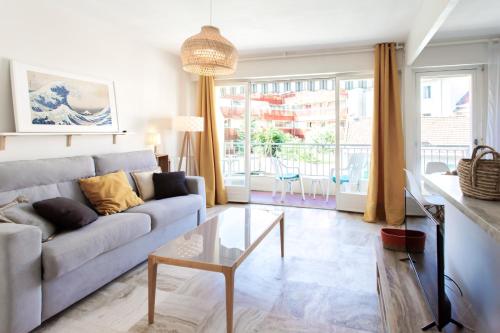 un salon avec un canapé et une table en verre dans l'établissement Studio Antibes 5min Train Station & Sea - AC & Balcony, à Antibes