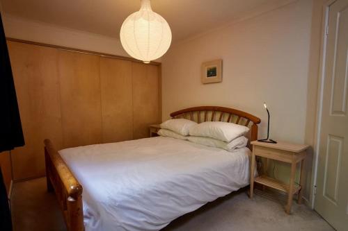 的住宿－Premium Central Stroud Apartment with Parking x2，一间卧室配有一张带台灯和桌子的床