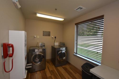 a laundry room with two machines and a window at Comfort Inn & Suites Newcastle - Oklahoma City in Newcastle