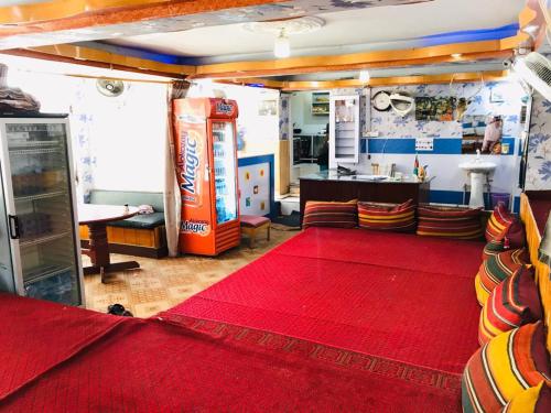 uma sala de estar com um tapete vermelho e uma máquina de refrigerantes em Millat Hotel & Noor Jahan Hotel Kandahar em Candaar