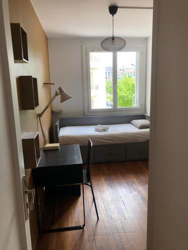 a room with a bed and a desk and a window at Chambre meublée café boulevard Joseph vallier in Grenoble