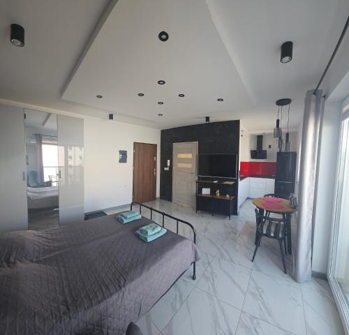 a large bedroom with a bed and a kitchen at Apartament Malta in Poznań
