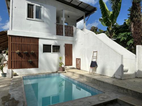 a villa with a swimming pool in front of a house at Tribal Xperience Guesthouse in San Vicente