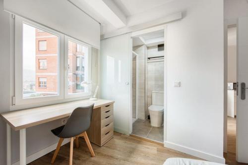 a bedroom with a desk with a chair and a window at 642A Apartamento con vistas en Oviedo in Oviedo