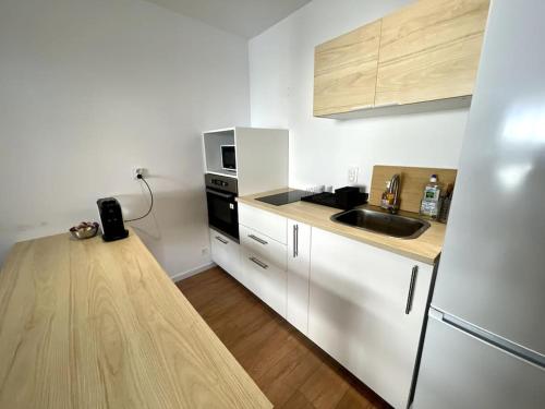 une petite cuisine avec un évier et un réfrigérateur dans l'établissement Superbe appartement 2P climatisé - Plages à pieds, à Juan-les-Pins