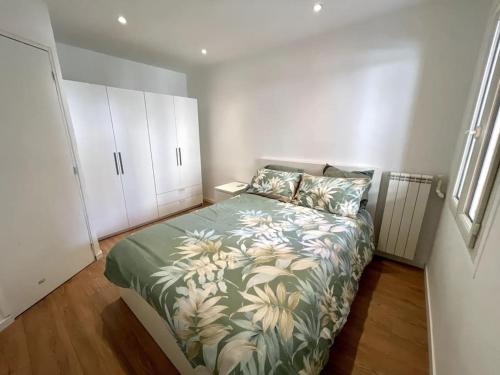 - une chambre dotée d'un lit avec un couvre-lit vert floral dans l'établissement Superbe appartement 2P climatisé - Plages à pieds, à Juan-les-Pins