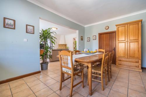 a kitchen and dining room with a wooden table and chairs at Tranquil Mansion - 3 Bed, Pool, BBQ & Gaming Room in Is-Swieqi