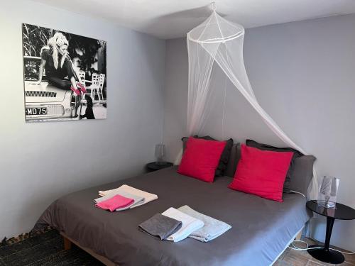 una camera da letto con letto e cuscini rosa di Villa Cote d'Asoet a Sainte-Maxime