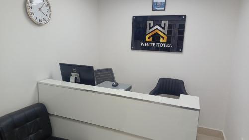 an office with a desk with two chairs and a clock at White Hotel in Quetta