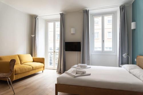 ミラノにあるYouhosty - Ticinese Suite 1のベッドとソファのあるリビングルーム