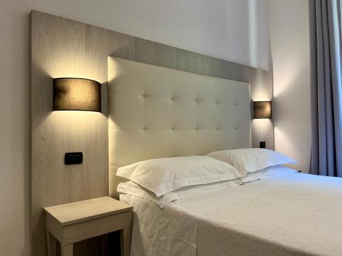 a bedroom with a large white bed with two lamps at Albergo Degli Amici in Monterosso al Mare