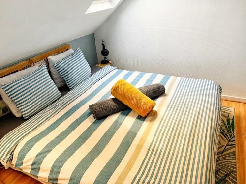 a bed with three pillows on top of it at Appartement agreable et zen in Boulogne-sur-Mer
