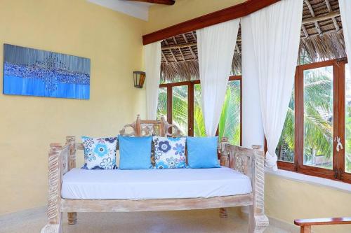 eine weiße Bank in einem Zimmer mit Fenstern in der Unterkunft Tembo Court Beach Cottage in Malindi