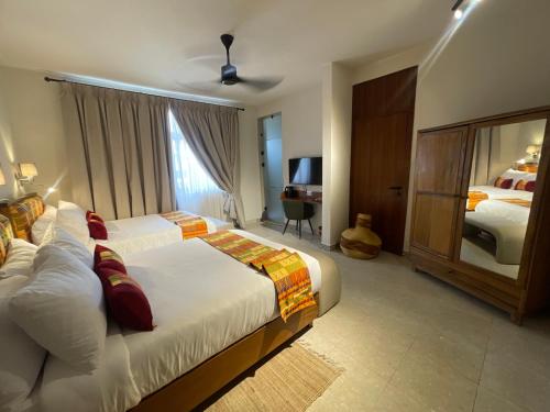 Pokój hotelowy z 2 łóżkami i lustrem w obiekcie Château NaNa Willine w Akrze