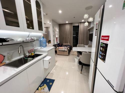 a kitchen with white cabinets and a living room at Resort Ori q9 3, giường, 2pn+ 2wc in Long Bình