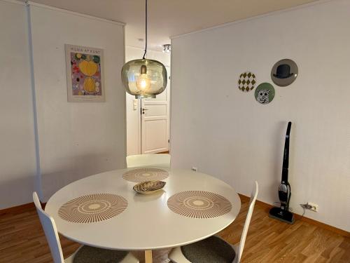 uma sala de jantar branca com uma mesa e cadeiras brancas em Enjoy Entire Condo near Stavanger airport em Sola
