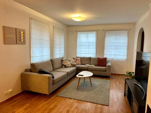 a living room with a couch and a table at Enjoy Entire Condo near Stavanger airport in Sola