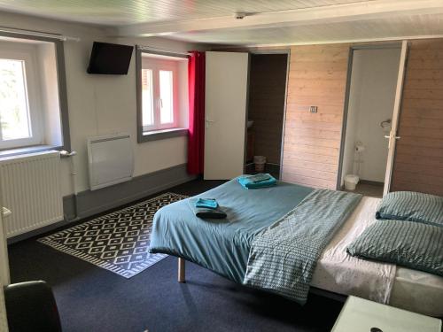 - une chambre avec un lit et une fenêtre rouge dans l'établissement Suite Familiale dans un ancien hôtel plein de charme, à Baume-les-Dames