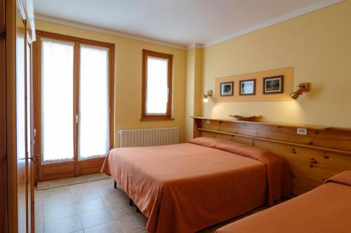 a bedroom with a bed and a window at Albergo Boschetto Ristorante Pizzeria in Druogno