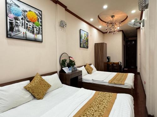 a hotel room with two beds and a chandelier at Quynh Moon homestay in Hanoi
