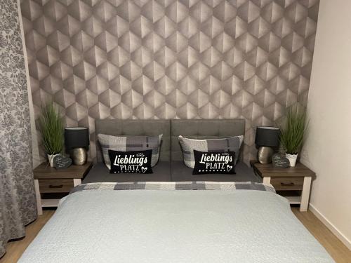 ein Schlafzimmer mit einem Bett und zwei Nachttische mit Pflanzen in der Unterkunft Ferienwohnung Viktoria in Gotha
