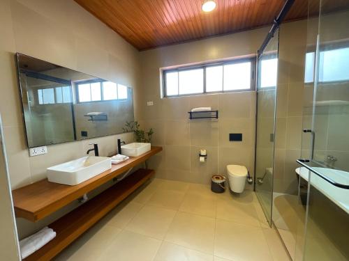 uma casa de banho com 2 lavatórios e um chuveiro em Château NaNa Willine em Accra