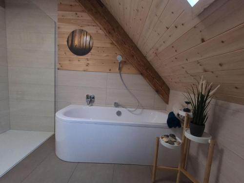 uma casa de banho com uma banheira branca num sótão em Schwarzwald Chalet - Karlshütte em Gütenbach