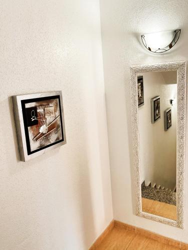a mirror on a wall with pictures on the wall at Villa Sol Ciudad Quesada in Ciudad Quesada