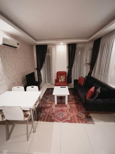 a living room with a couch and a table and chairs at AQUA CİTY SUİT in Antalya