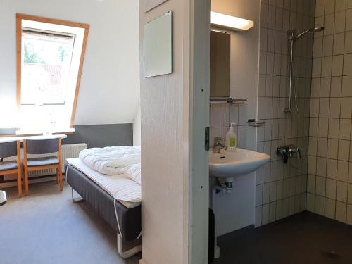 uma casa de banho com uma cama e um lavatório num quarto em Danhostel Ringsted em Ringsted