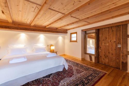 ein Schlafzimmer mit einem Bett und einer Holzdecke in der Unterkunft Gîte Bei der Kirche 4 étoiles in Mundolsheim
