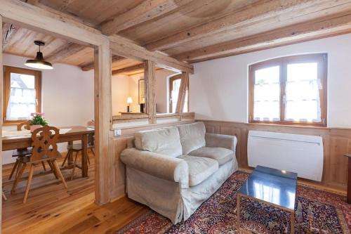 un salon avec un canapé et une table dans l'établissement Gîte Bei der Kirche 4 étoiles, à Mundolsheim