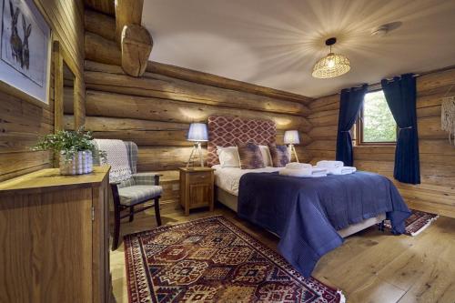 a bedroom with a bed in a log cabin at Alder Lodge with Hot-tub in Carlisle