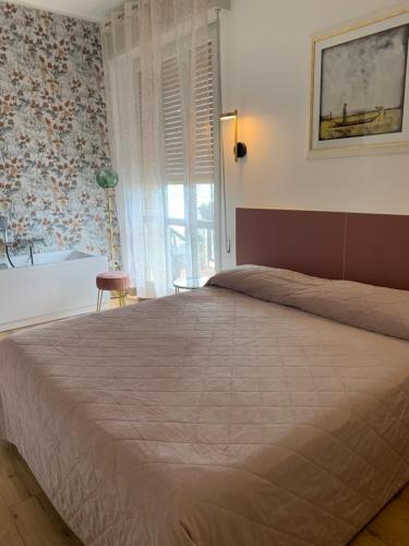 a bedroom with a large bed and a window at A Casa Così B&b in Marzocca di Senigallia