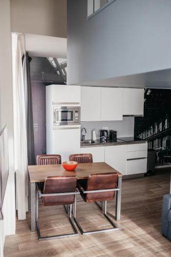 a kitchen with a wooden table and chairs at YAYS Amsterdam Maritime by Numa in Amsterdam